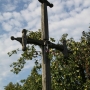 Drewniany krzyż przydrożny, obok mały żelazny