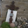 Krzyż żeliwny z huty sztabińskiej hr.Brzostowskiego i kule armatnie wydobyte z terenu grodziska.