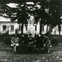 Grupa osób na ławce przed dworem w Krynicy, gmina Suchożebry