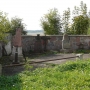 Lapidarium przy murowanym ogrodzeniu stworzone z fragmentów nagrobków z XIXw.