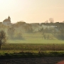 Wiosenny widok na zespół klasztorny dominikanów i cerkiew przez snujący się o zachodzie dym.