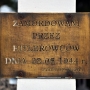 Tabliczka na krzyżu upamiętniającym pomordowanych mieszkańców Jamin przez hitlerowców w 1944 roku. 